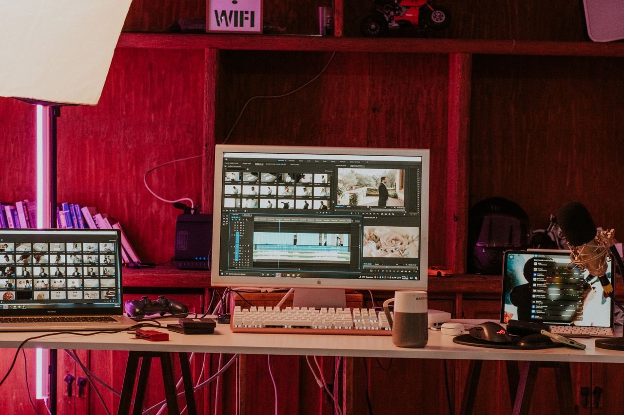 team-02 A professional video editing workspace featuring monitors, keyboard, and microphones in a studio setting.